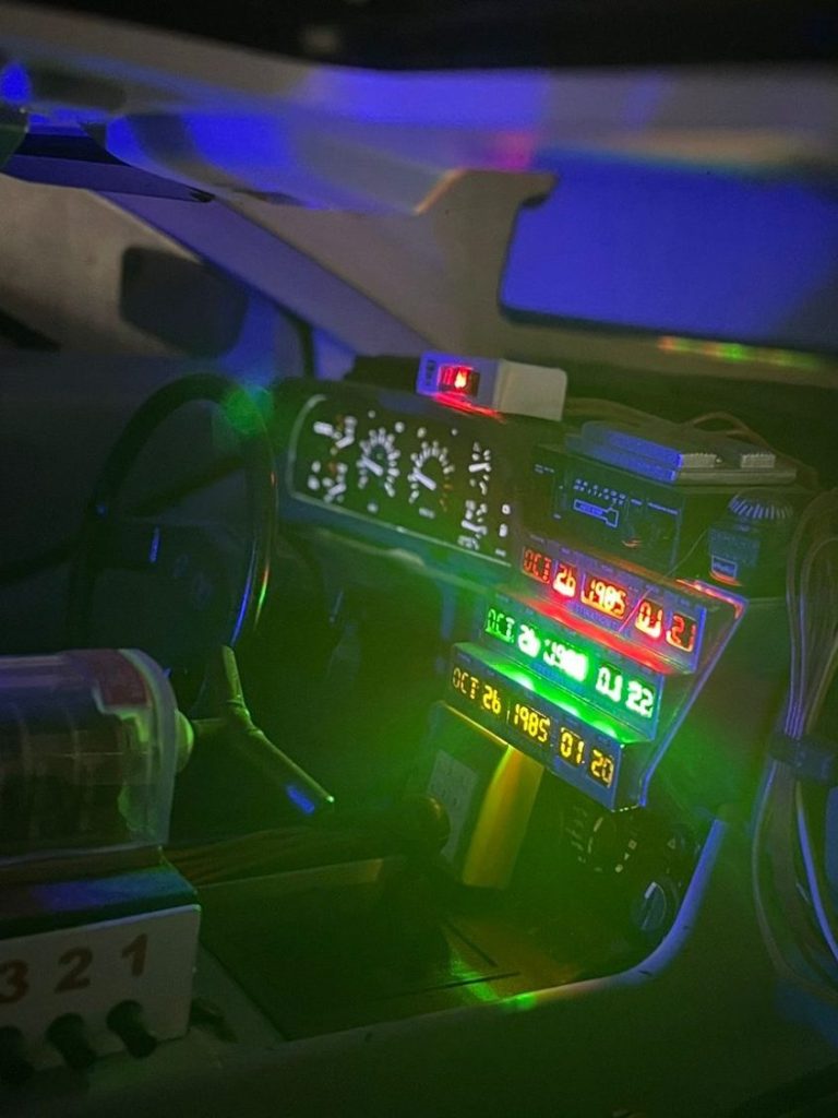 Ein Dashboard mit bunten Lichtern und mehreren Messgeräten in einem futuristischen Design.