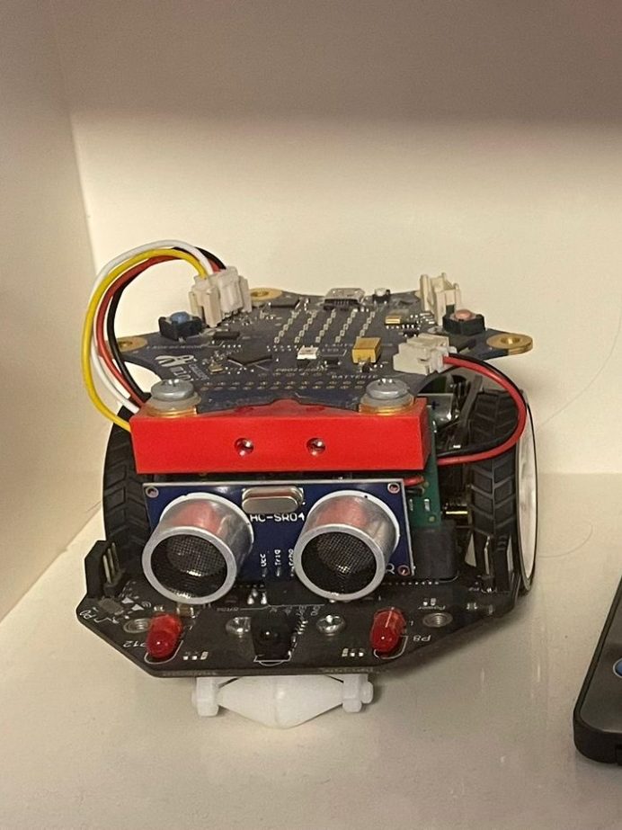 Fernbedienung liegt zwischen zwei technischen Geräten auf einer Oberfläche.